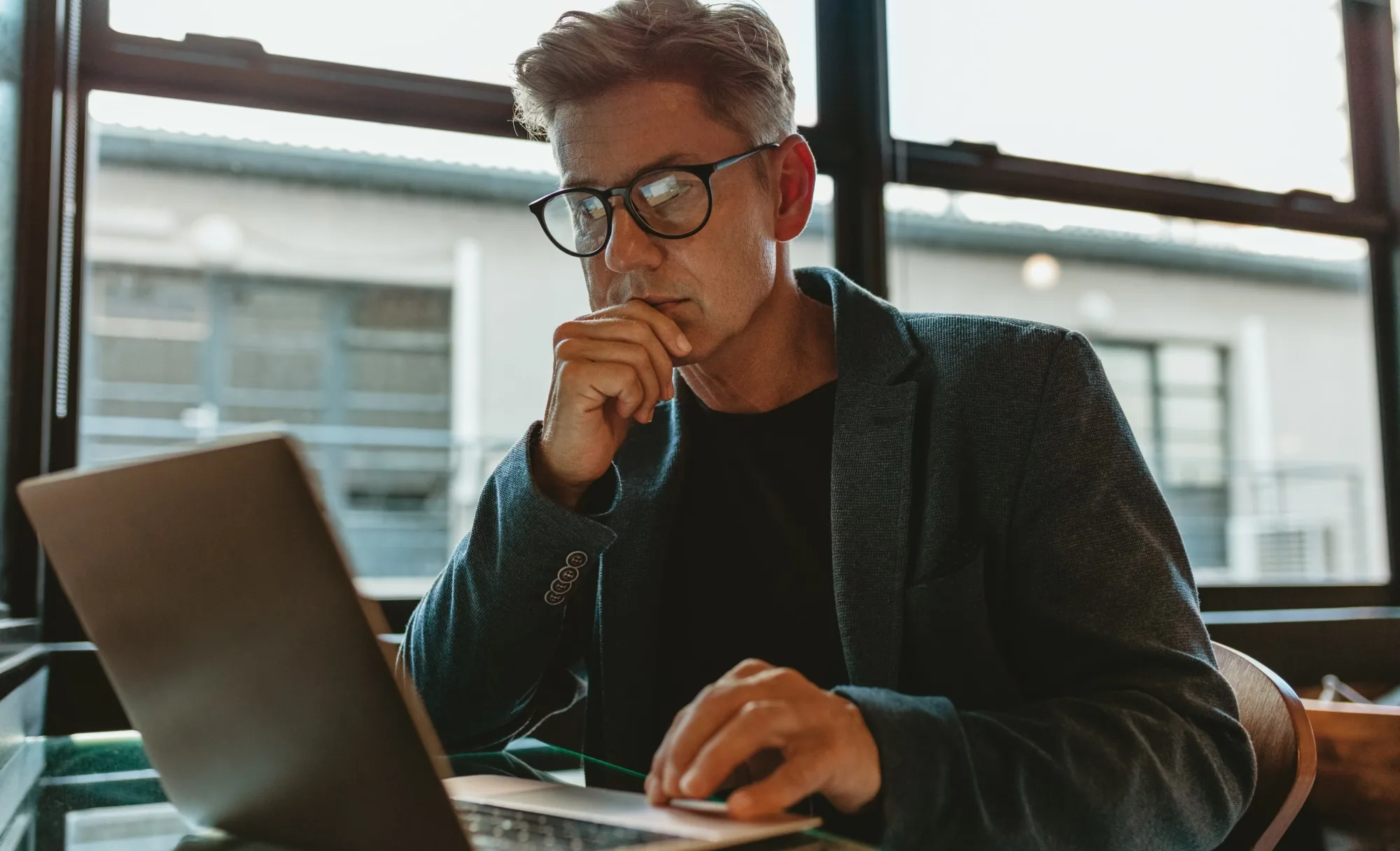 Analyst reviewing policy records on a laptop