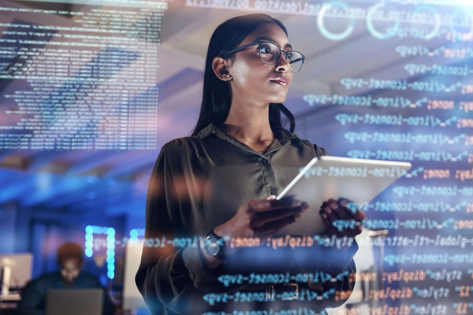 Engineer with a tablet and glasses, lines of code reflected around her