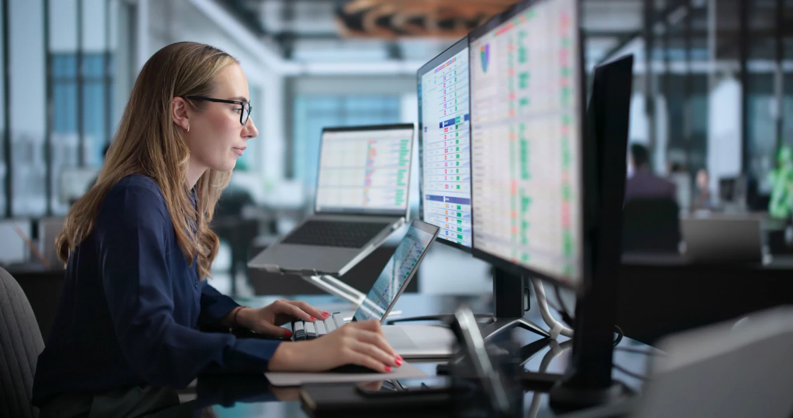 Engineer monitoring data pipelines across multiple screens